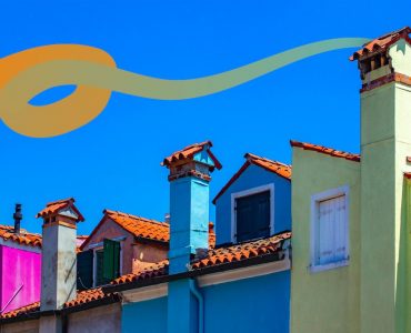 a row of colorful houses with a blue sky in the background