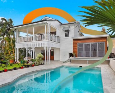 a large white house with a pool in front of it