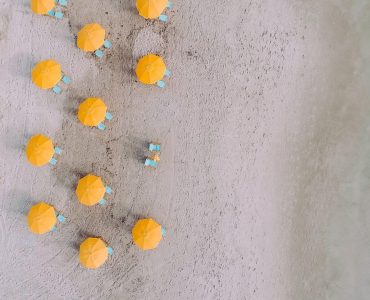 a group of blue and yellow candies sitting on top of a sandy beach