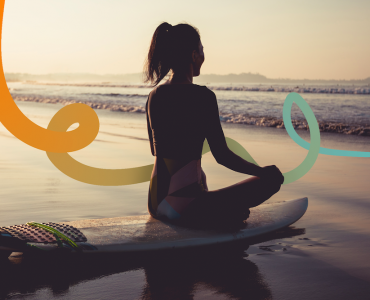 a woman sitting on a surfboard on the beach