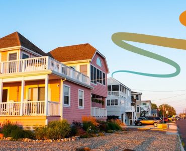 a row of houses on a beach with a rainbow colored wave coming out of the house