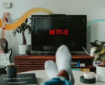 a person's feet resting on a table in front of a television