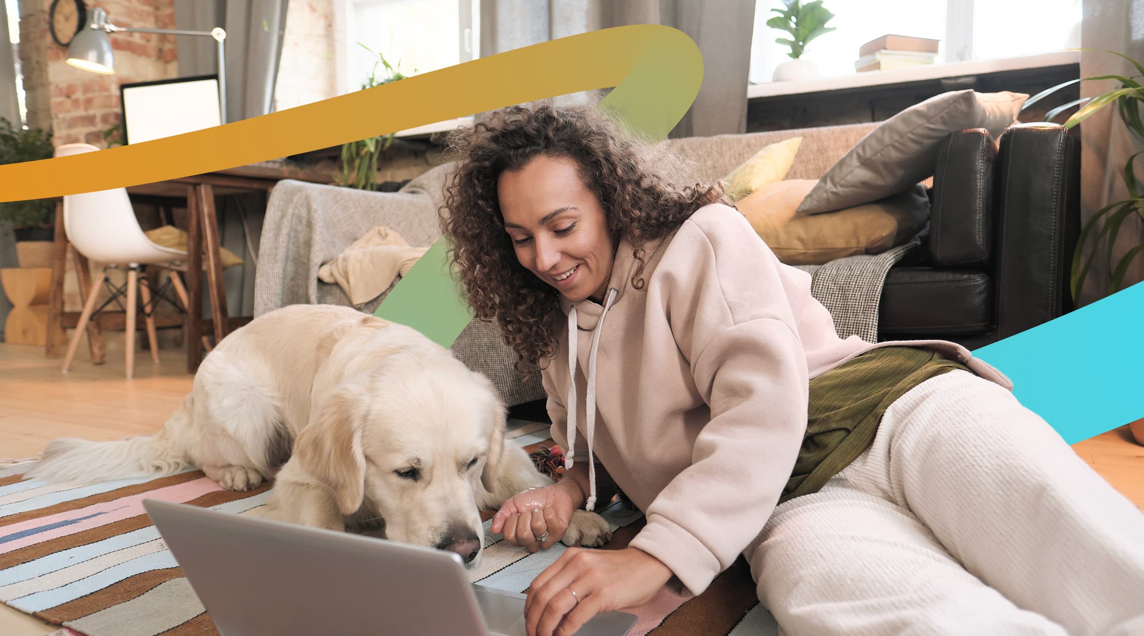a woman sitting on the floor with a laptop and a dog