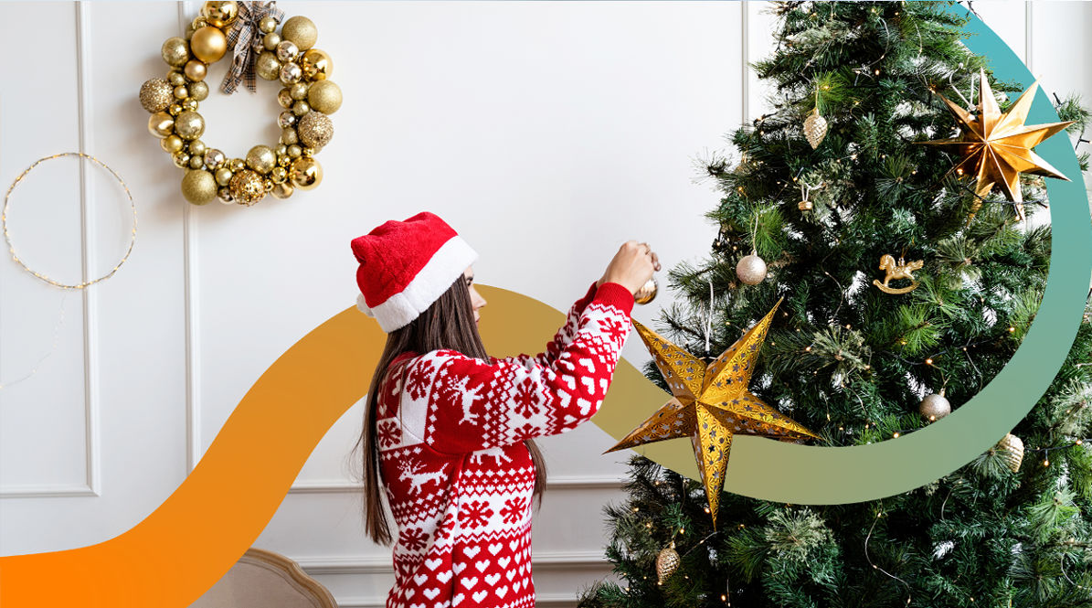 a woman decorating a christmas tree with a star