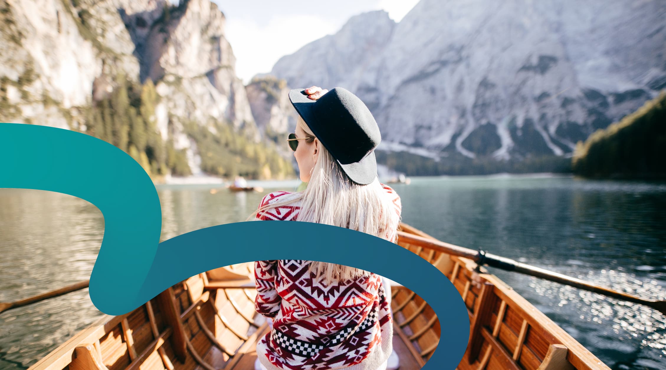 a woman in a boat on a lake with mountains in the background