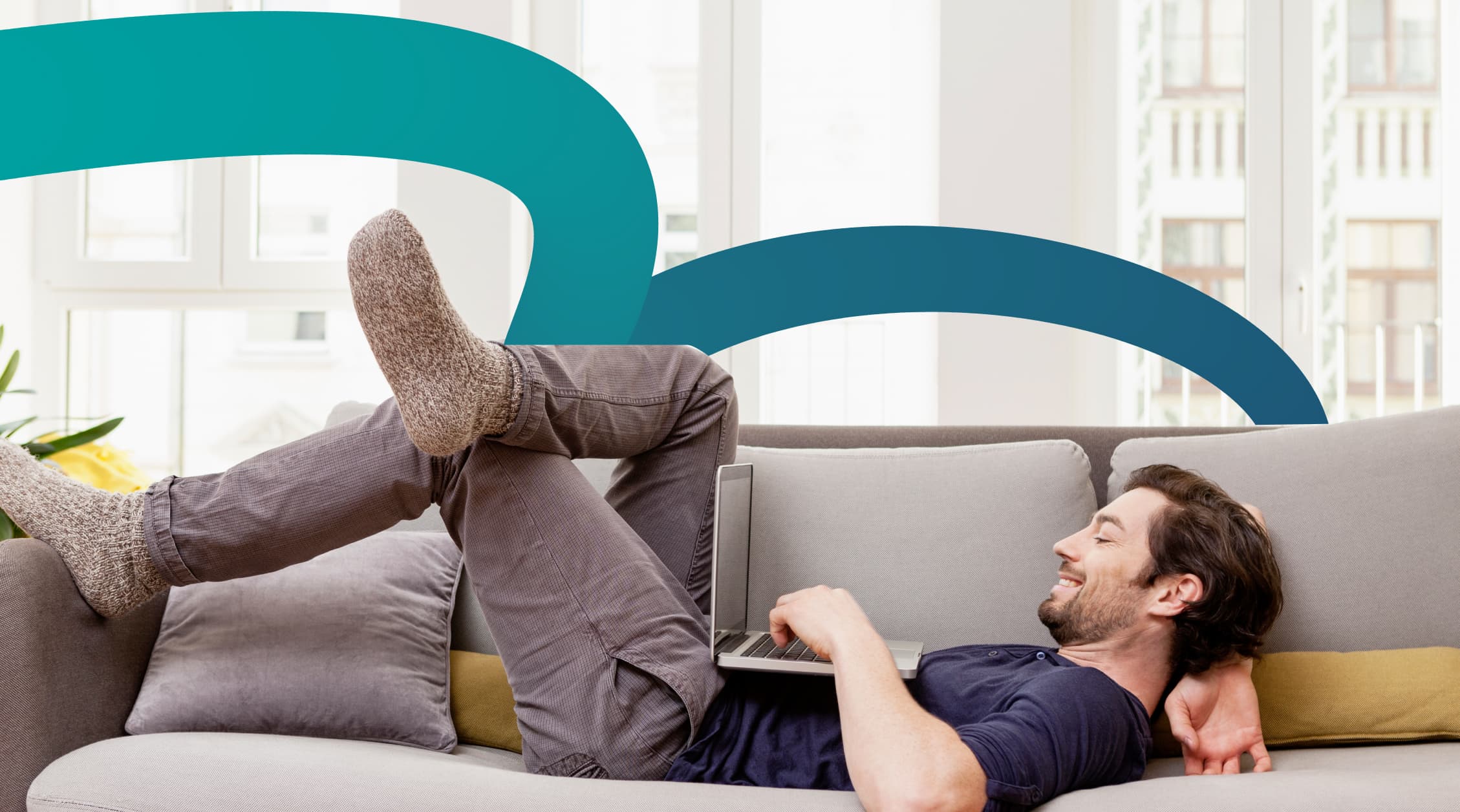 a man laying on a couch with a laptop searching for rentals